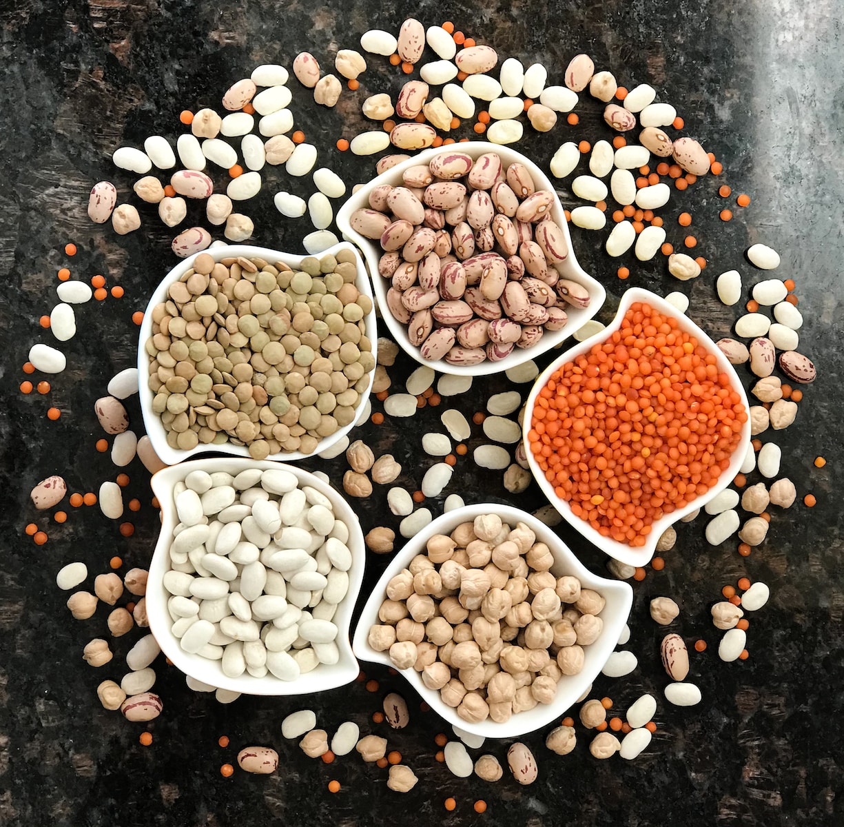 brown and white lentils on black surface