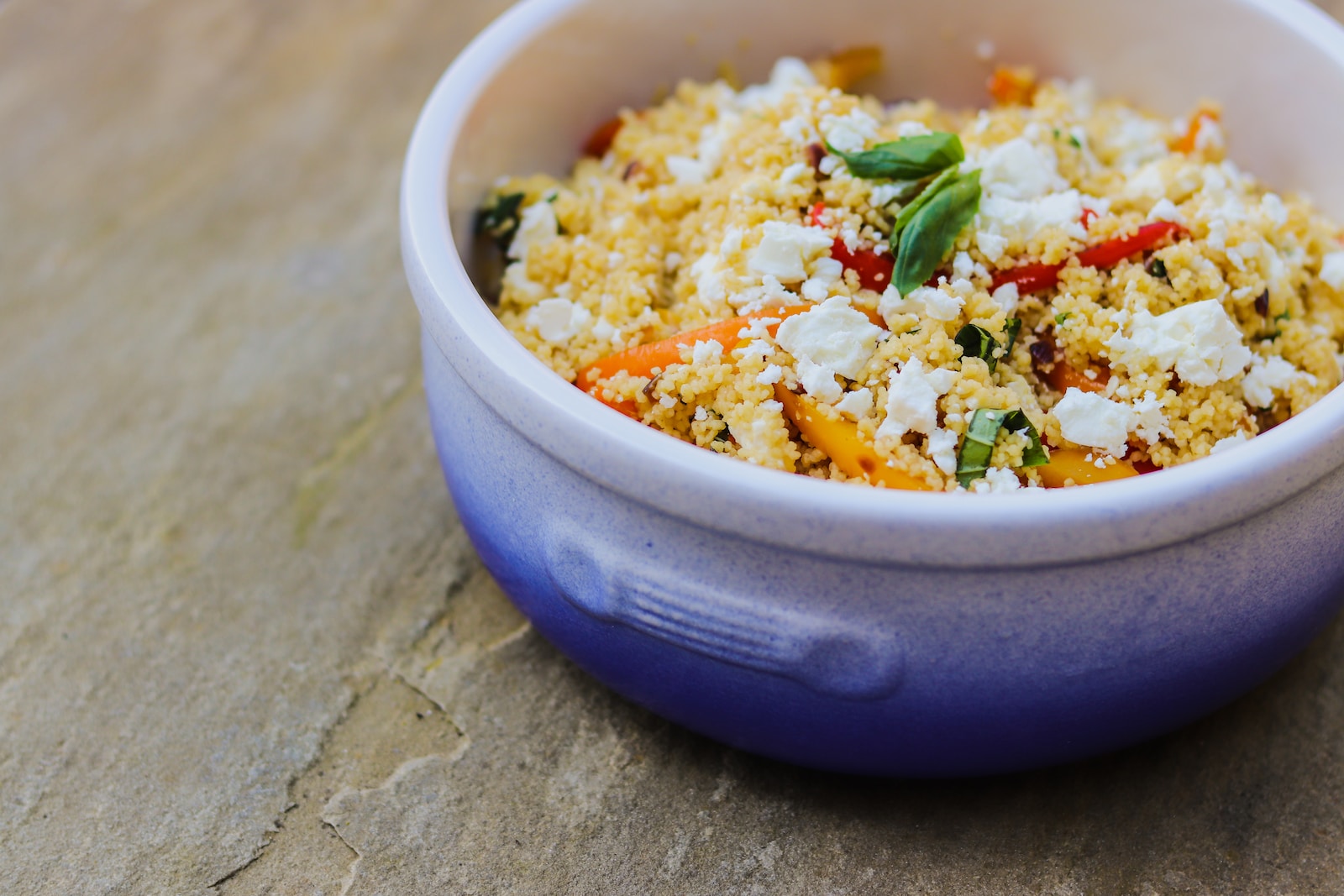 a blue bowl filled with food on top of a wooden table