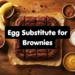 Egg substitute for brownies including Greek yogurt, flax seed, banana, and applesauce displayed next to freshly baked chocolate brownie squares